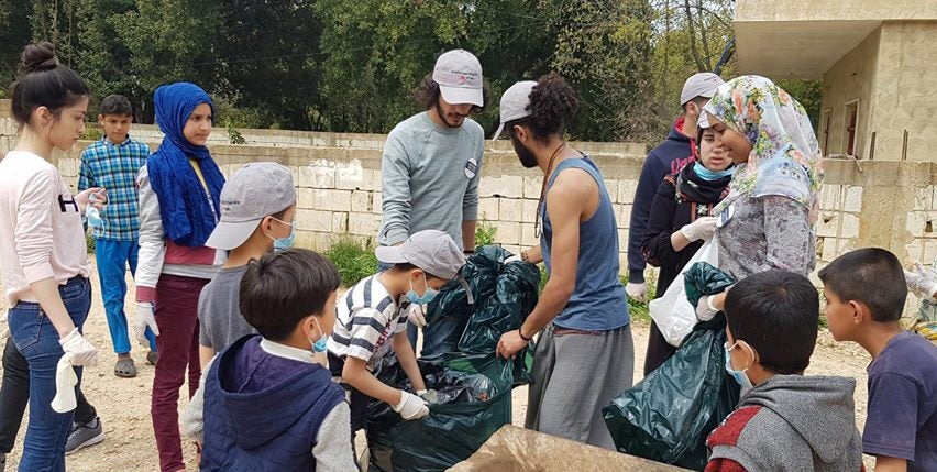 Razan Amani with volunteers cleaning up trash.