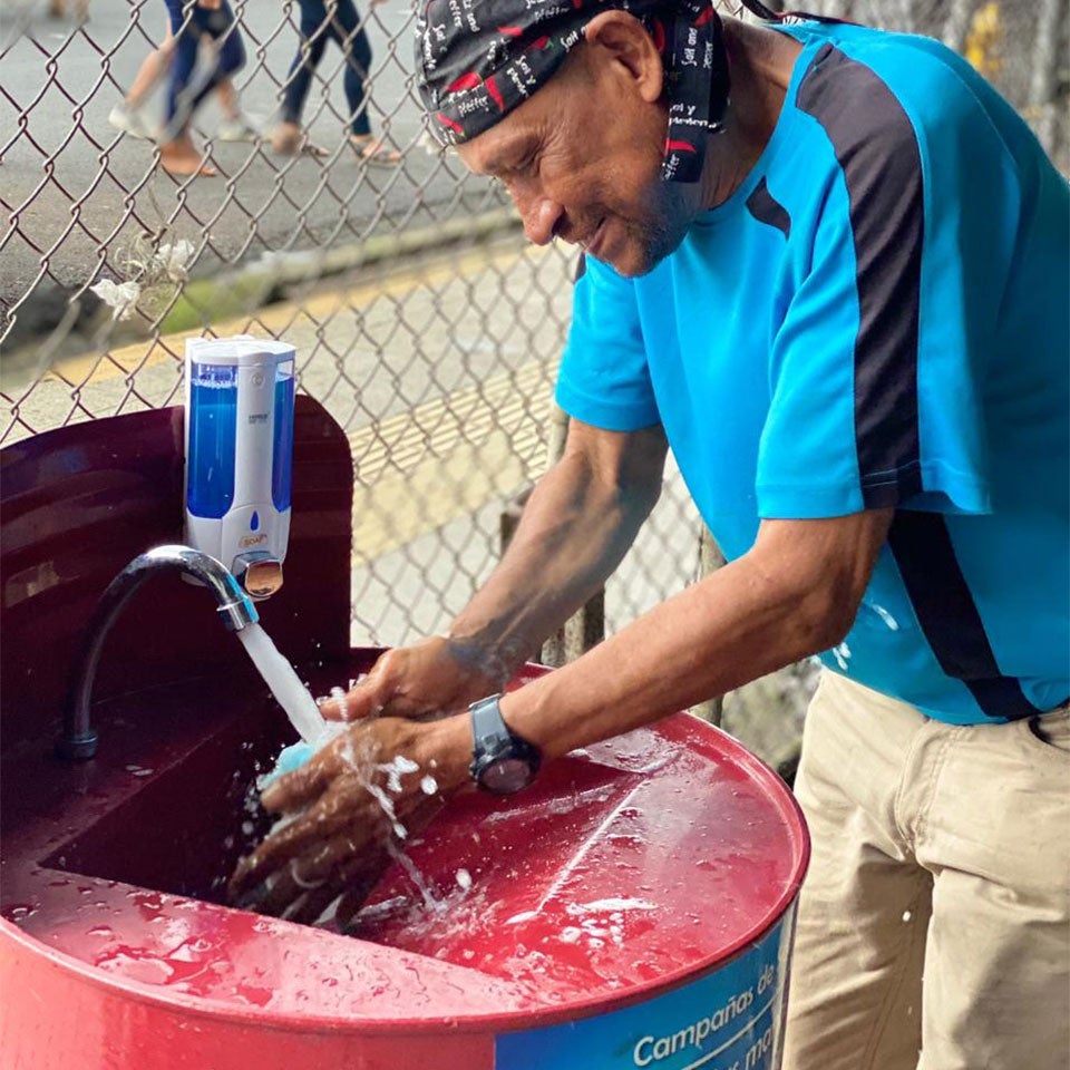 Man washing his hands in a handwashing station 