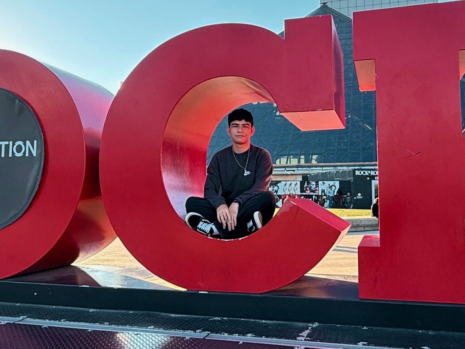 Josimar Madrigal smiling while posing inside the giant red "C" of the Cleveland sign near the Rock & Roll Hall of Fame during his exchange in Ohio.